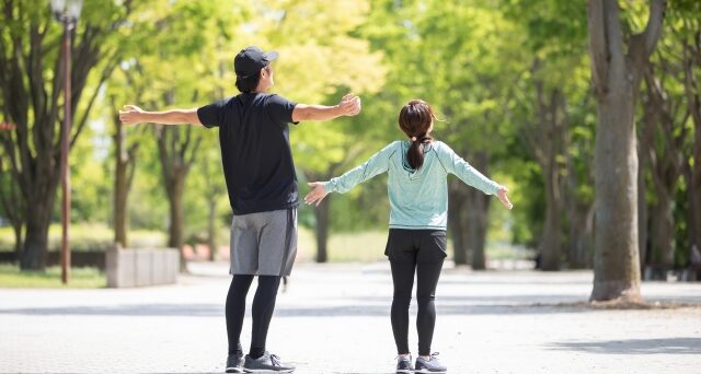 外で深呼吸をする男女