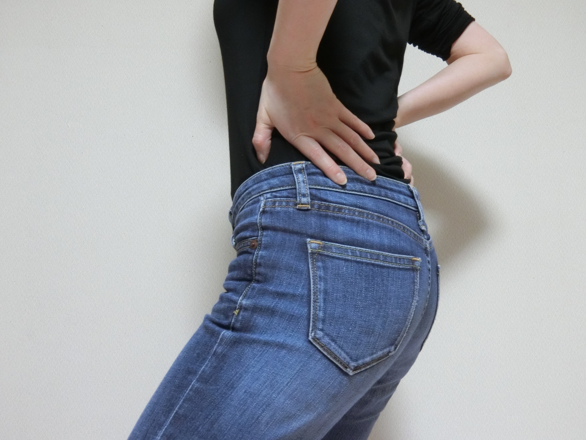 腰に手を当てている女性の腰回りの写真